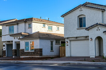 Newly finished homes in a modern subdivision, featuring stucco exteriors, stone accents, and clean architectural lines