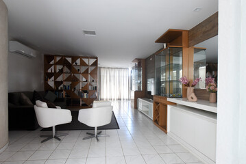 modern living room interior design, white floor and stylish wooden furniture, contemporary residential architecture, spacious apartment lounge area, white design armchairs and natural light