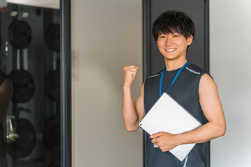 Male gym trainer, personal trainer, and instructor with tablet