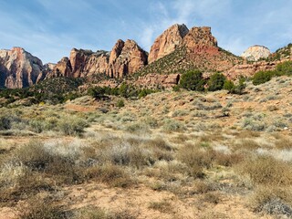 Fototapeta premium Zion National Park in Utah. Human History Museum, shuttle stop 2. Road less traveled and explored. Beautiful landscape, mountain, canyon, valley, trees, grass, desert, sand. Gorgeous parking lot view.