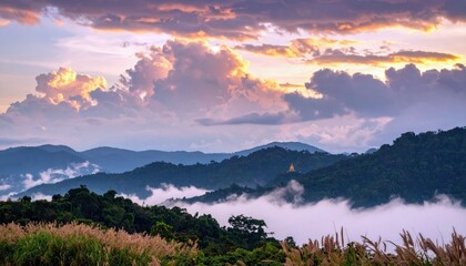 Scenic landscape of mountains and clouds at sunset, with golden light illuminating the scene.