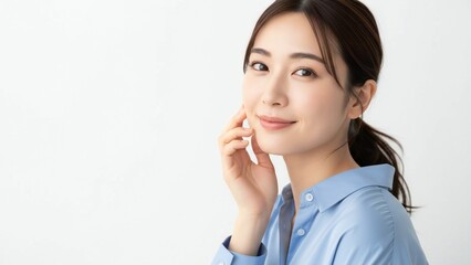 Smiling Asian woman's face with hand gently touching cheek looking to the side studio lighting chinese korean japanese beauty
