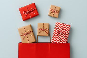 Stylish gifts overflowing from a vibrant red shopping bag against a serene backdrop, ready for holiday promotions and festive designs, creating joyful anticipation