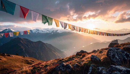 Colorful prayer flags strung across a mountain range at sunset. The landscape features rolling hills, rocky terrain, and snow-capped peaks under a dramatic, clo