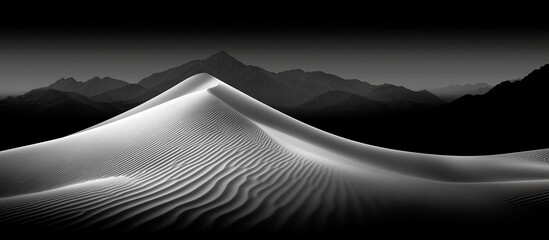 Monochromatic landscape featuring sand dunes and distant mountains under a dark sky