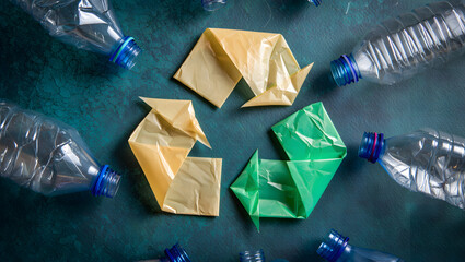 Recycling symbol made from plastic bottles and bags on a dark background