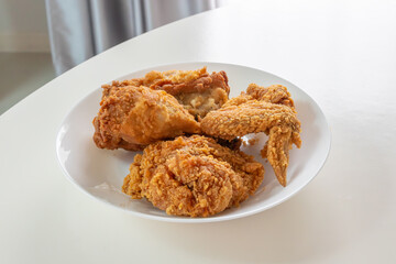 Crispy fried chicken in white plate on wood table