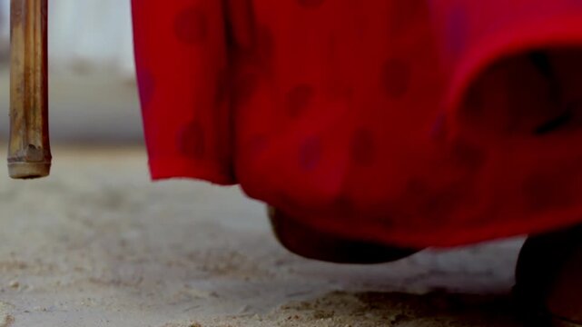 Colorful flamenco skirts swaying in motion on the Roc&iacute;o path, full of rhythm, faith and Andalusian grace Close-up of colorful flamenco dresses moving over sand as pilgrims walk the Roc&iacute;o trail