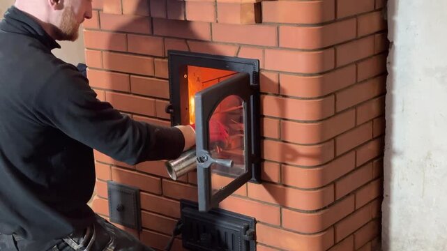 A master stove fitter lights a test fire in the stove he built. Construction of a heating stove. Vertical video