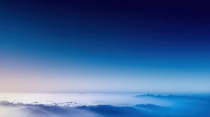 Obraz premium A breathtaking aerial view of mountains and clouds under a serene gradient sky, showcasing the beauty of nature.