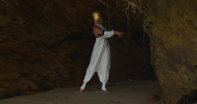 A young girl dressed in cosplay walking along a Caribbean beach under a dramatic, overcast sky.