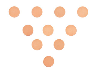detailed photograph of ten small, round, peach-colored medicinal pills or tablets arranged geometrically in a pyramid shape, isolated on black.