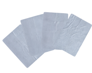 overlapping isolated white square papers or adhesive labels with rounded corners, displaying a heavily wrinkled and creased texture against black.