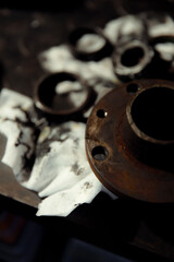 Replacing a wheel bearing in a classic car. Old vehicle restoration concept. Worn wheel bearing on a dirty, oily napkin. Metal textured background.