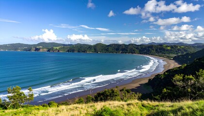 A bright and vibrant ocean bay surrounded by lush green hills under a clear blue sky. 