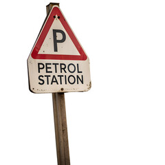 A weathered petrol station sign on a wooden post against a dark background view