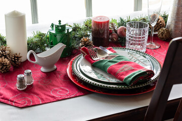 A beautifully decorated place setting with decorations against a sunny window.