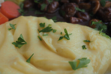 Creamy mashed potatoes garnished with parsley on a plate