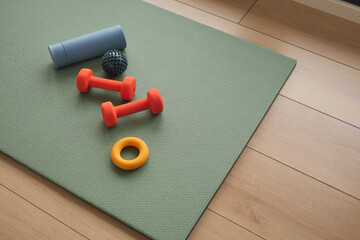 Workout equipment arranged on a green exercise mat