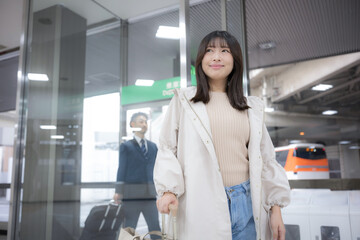 Obraz premium A woman carrying a suitcase while moving through places like stations and airports An image of going on a trip or out for fun