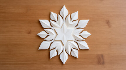 Fototapeta premium A delicate white paper snowflake design featuring layered leaves and a star at the center, set against a wooden backdrop.
