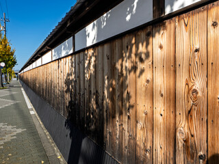 秋陽に輝く木塀のある街角