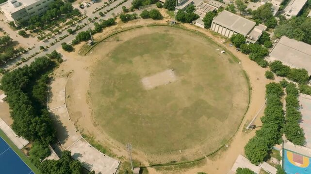 Aerial view of the cricket ground at NED University of Engineering and Technology in Karachi Pakistan showcasing the green field and surrounding buildings.