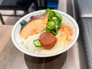朝食バイキングでお茶碗に盛った、炊き立てご飯の上に乗せた焼き鮭と梅干し。