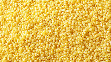 bright yellow raw millet grains forming an organic cereal background with rich natural texture, creating a healthy food concept with warm color and rustic detail
