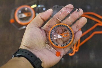Person hand holding compass for navigation and direction. Feeling prepared for outdoor adventure, exploration, and survival on journey or hiking trip © CoreRock