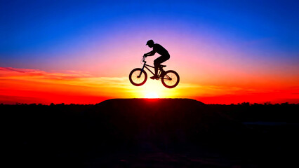 Obraz premium Bmx bike silhouette sunset jump extreme sport bicycle rider sky clouds orange red blue freedom adventure action lifestyle recreation outdoor nature challenge skill trick adrenaline speed