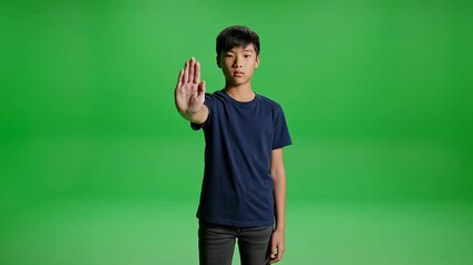 Young Boy Gesturing Stop on Green Screen A Powerful Visual for Prevention Safety and Awareness Campaigns Ideal for Educational and Social Impact Projects.