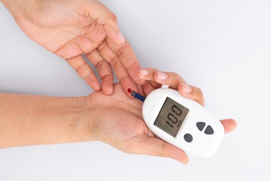 Woman's hands checking diabetes and hyperglycemia with digital blood sugar meter. Healthcare and medical concept	
