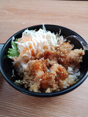 Top view of healthy chicken bowl with mayonnaise sauce and rice on wood background. asian food.