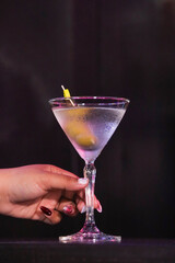 An elegant martini cocktail is held by a hand