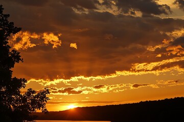 Golden sunset over a tranquil lake, with dramatic clouds (1)