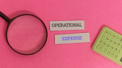 Business finance concept illustrating the analysis of company operating expenditures with a magnifying glass and a calculator for accounting and budgeting