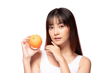 Asian young woman holding orange fruit with gentle expression and clear skin, healthy lifestyle concept