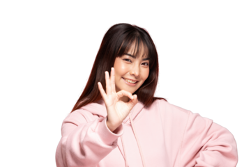 Asian young woman in pink hoodie making okay gesture and smiling confidently with casual pose and warm expression