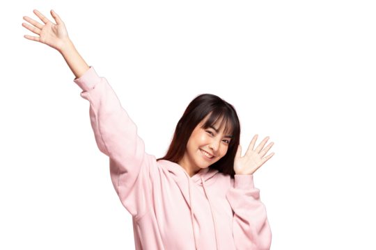 Asian Smiling young woman wearing pink hoodie waving both hands energetically with cheerful expression in studio portrait