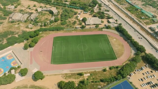Aerial view of NED University of Engineering and Technology Karachi campus featuring the football field and running track on a sunny day in Pakistan