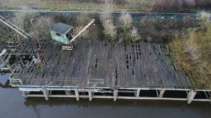 Aerial view of an abandoned crane on a derelict wooden dock