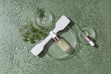 Obraz premium Composition with bottle of dill cosmetic product and Petri dishes in water on green background, closeup