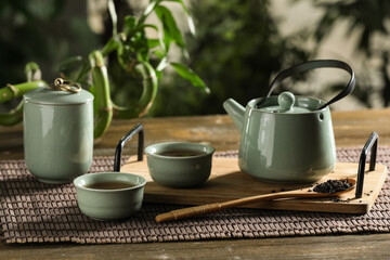 Fototapeta premium Tray with cups and teapot of hot tea on wooden table outside
