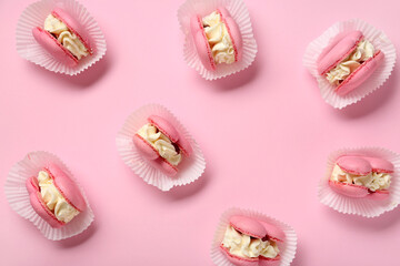 Many sweet heart-shaped macaroons on pink background. Valentine's Day celebration
