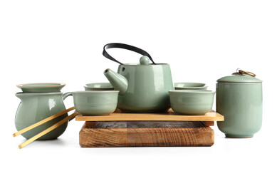 Wooden tray with teapot, cups, jug and bamboo tongs on white background