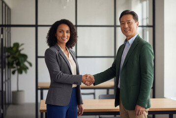 Diverse business colleagues shaking hands in a modern office