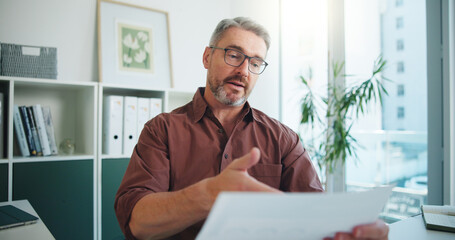 Portrait, video call and man in workplace, documents and talking with financial agency. POV, investor or mature person with paperwork, advice or report for investment audit or feedback for trading