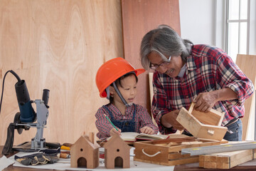 Asia retirement carpenter man spends time with cheerful granddaughter in carpentry studio, aged people enjoy teaching woodwork skill to adorable niece, family hobby lifestyle parenthood DIY handmade