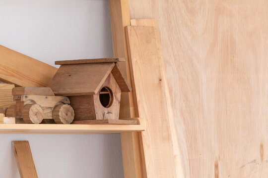 Handmade birdhouse DIY by a professional carpenter or small retail business, full of carpentry equipment workshop sawdust, safety helmet, hammer, and measuring in studio, stack of wooden background